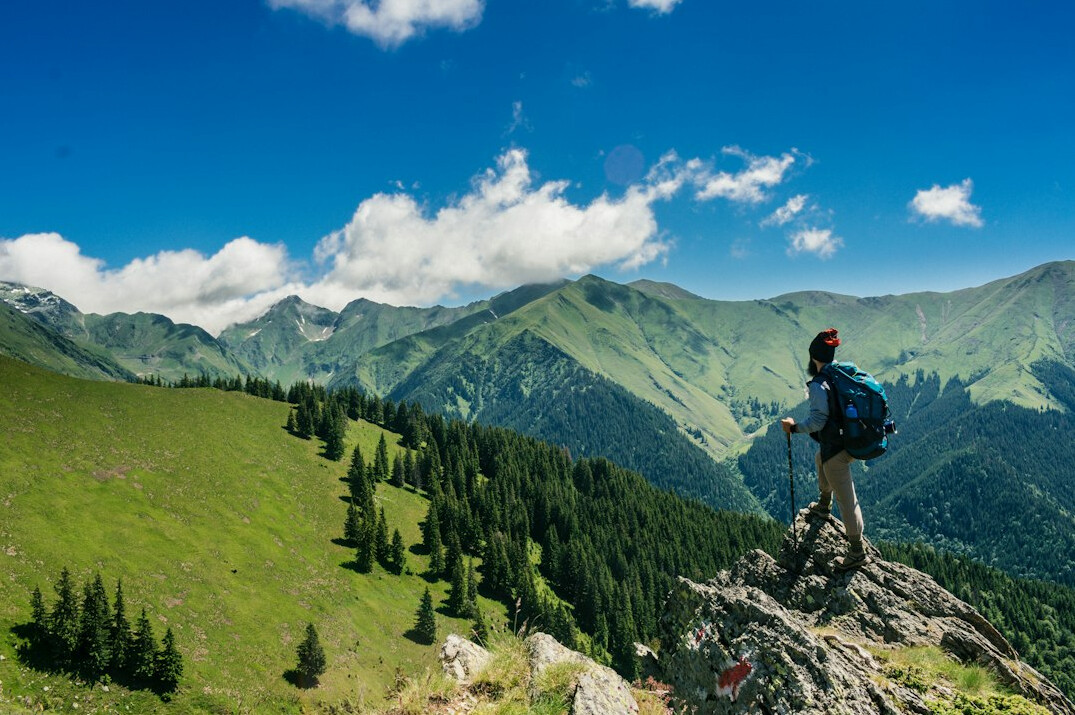 Traveler with backpack looking at mountain landscape